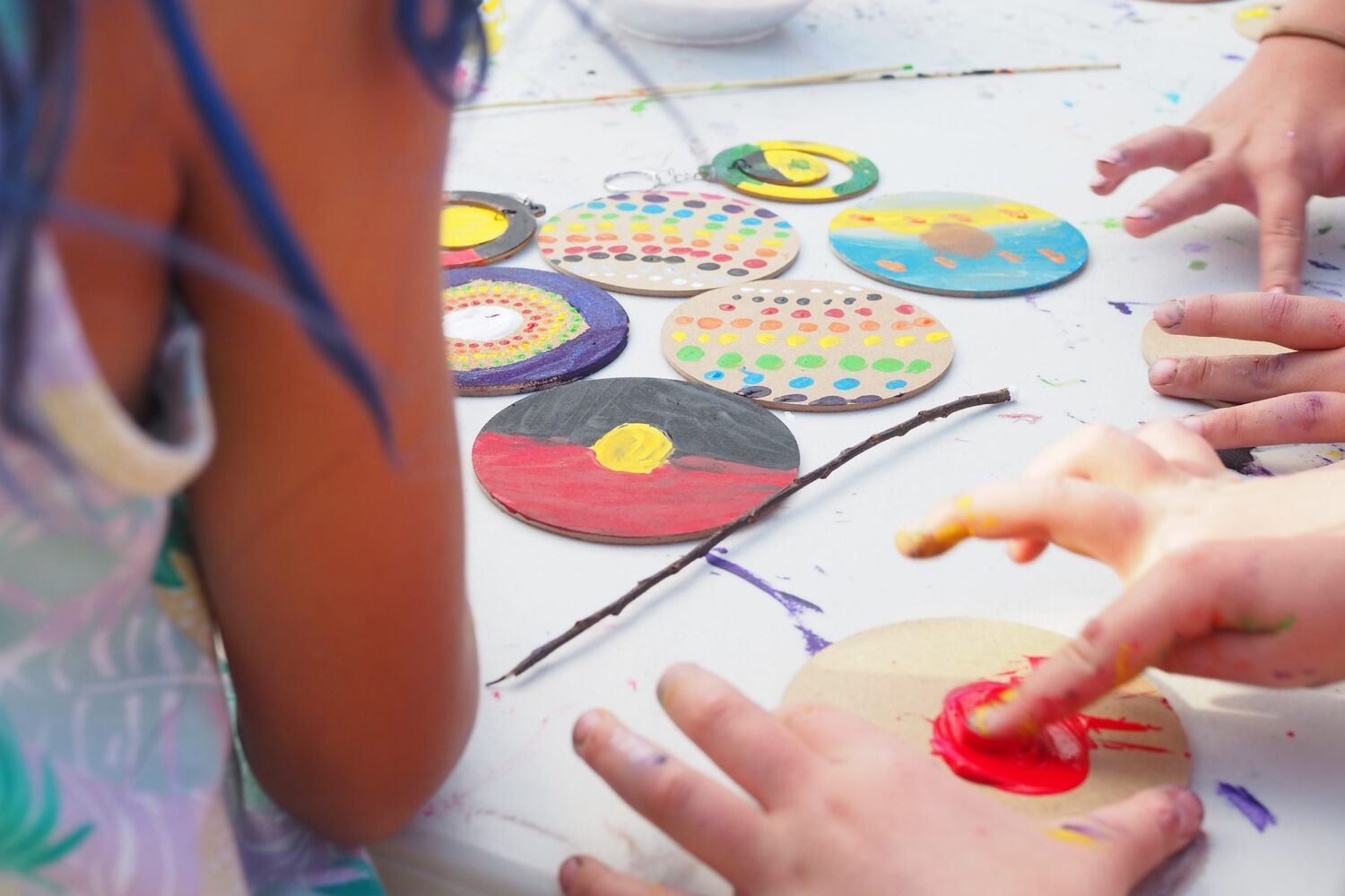Children painting aboriginal artwork with their fingers