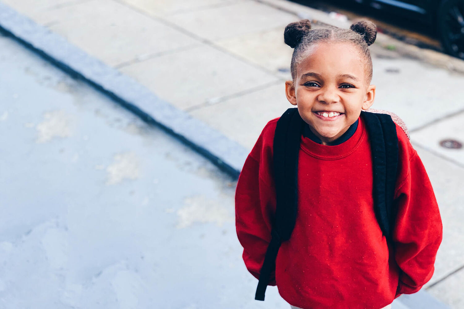 Little Girl Smiling In Big Red Sweater