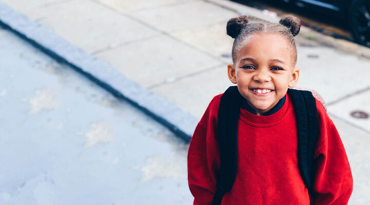 Little Girl Smiling In Big Red Sweater