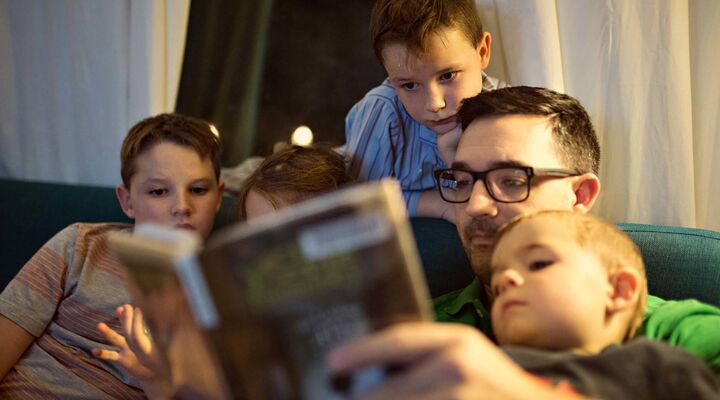 Father Reading Books To His Young Children