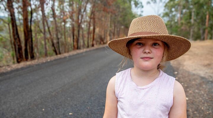 Young Girl On Country Road Wearing Hat