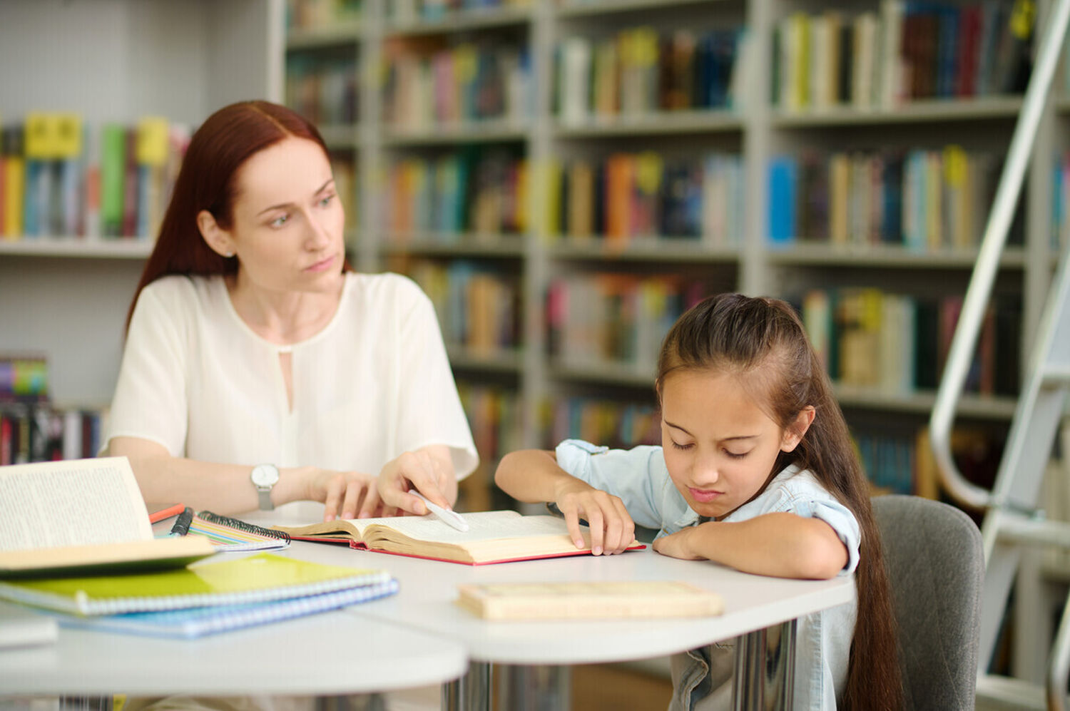 Woman looking at girl refusing to study