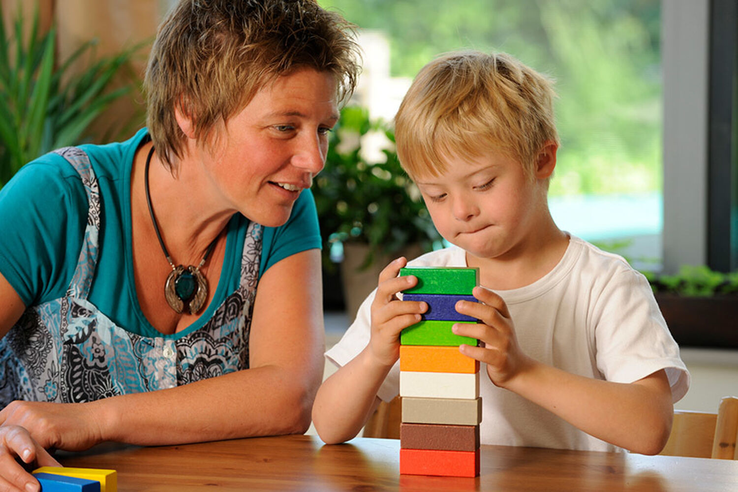 Boy Playing With Blocks While Lady Watches