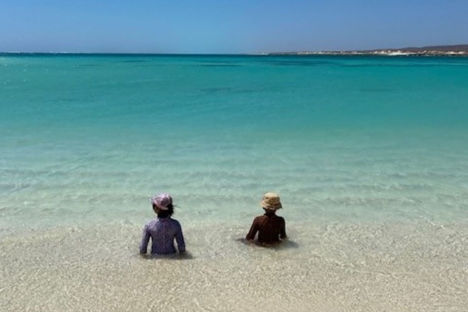 Two Aboriginal Girls Sitting At The Beach
