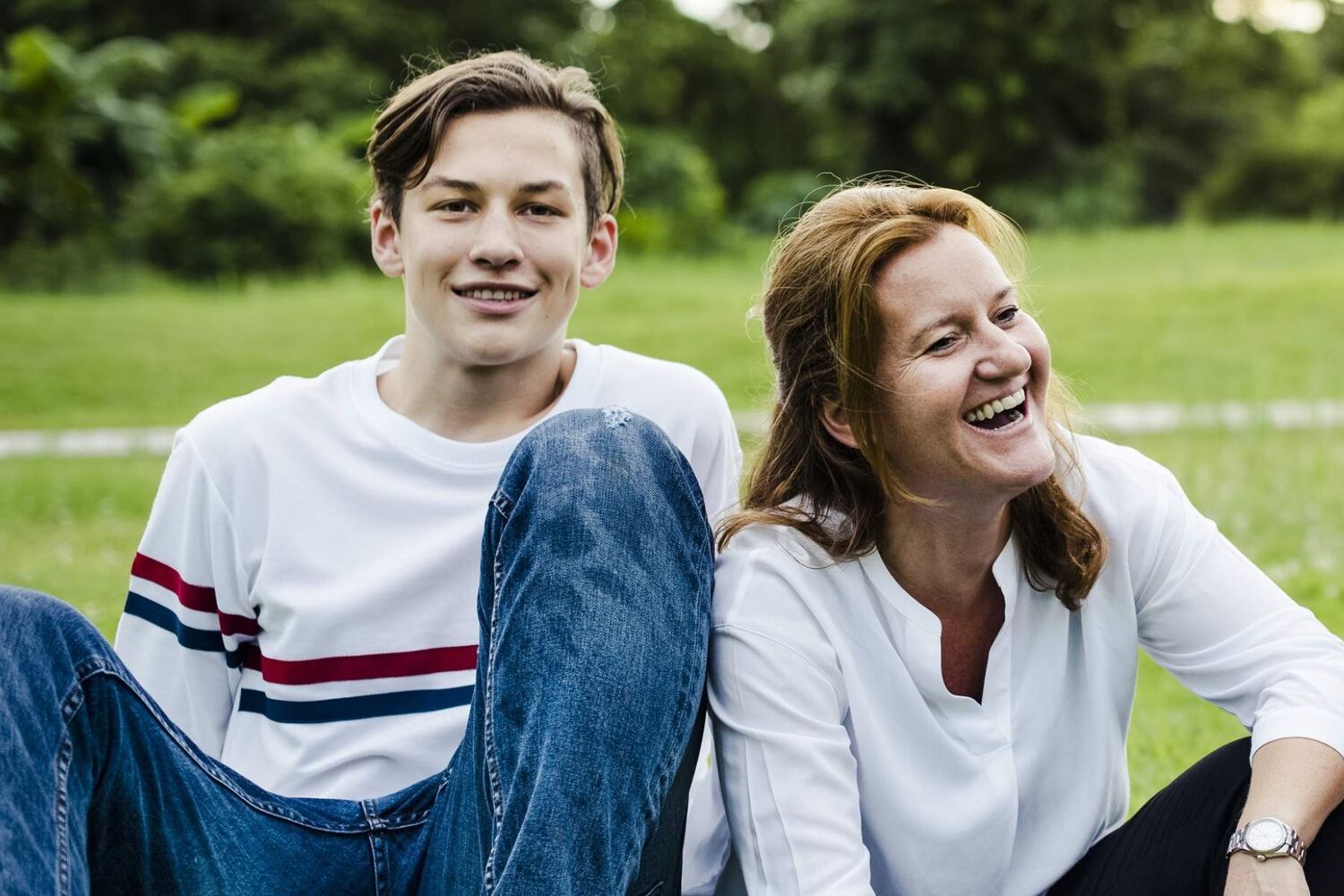 Mother And Teenage Son Sitting In A Field