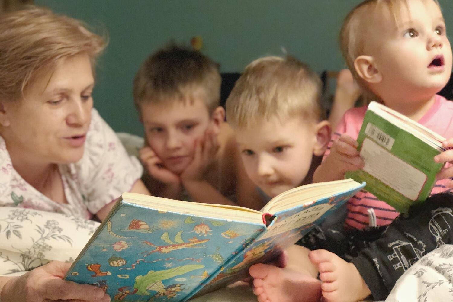 A Grandmother Reads A Funny Book To Her Grandchildren Before Going To Bed