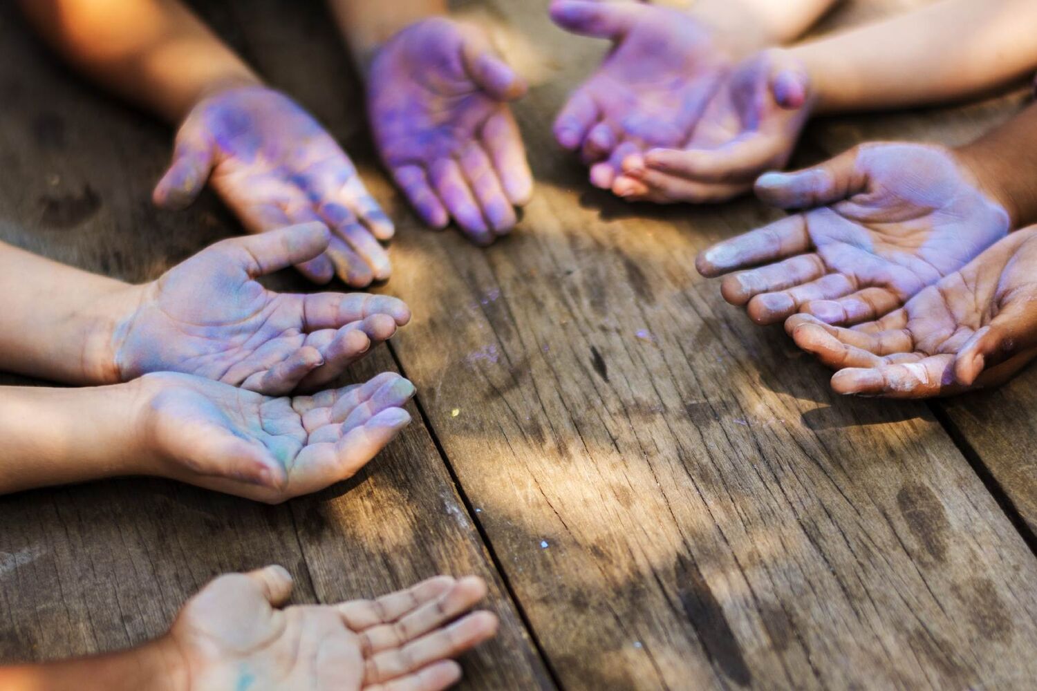 Five Sets Of Childrens Hands Covered In Purple Chalk