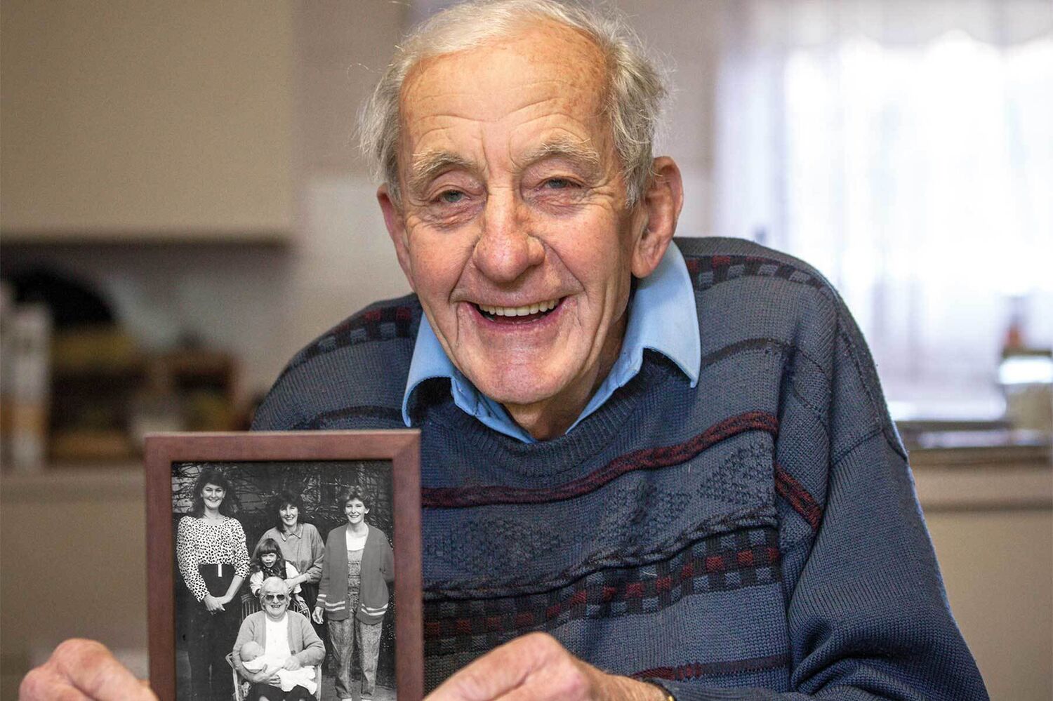 Peter Holding A Photo Of His Family