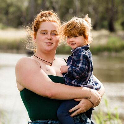 Ethicah holding daughter in front of lake