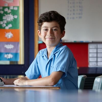 School boy setting at desk by himself